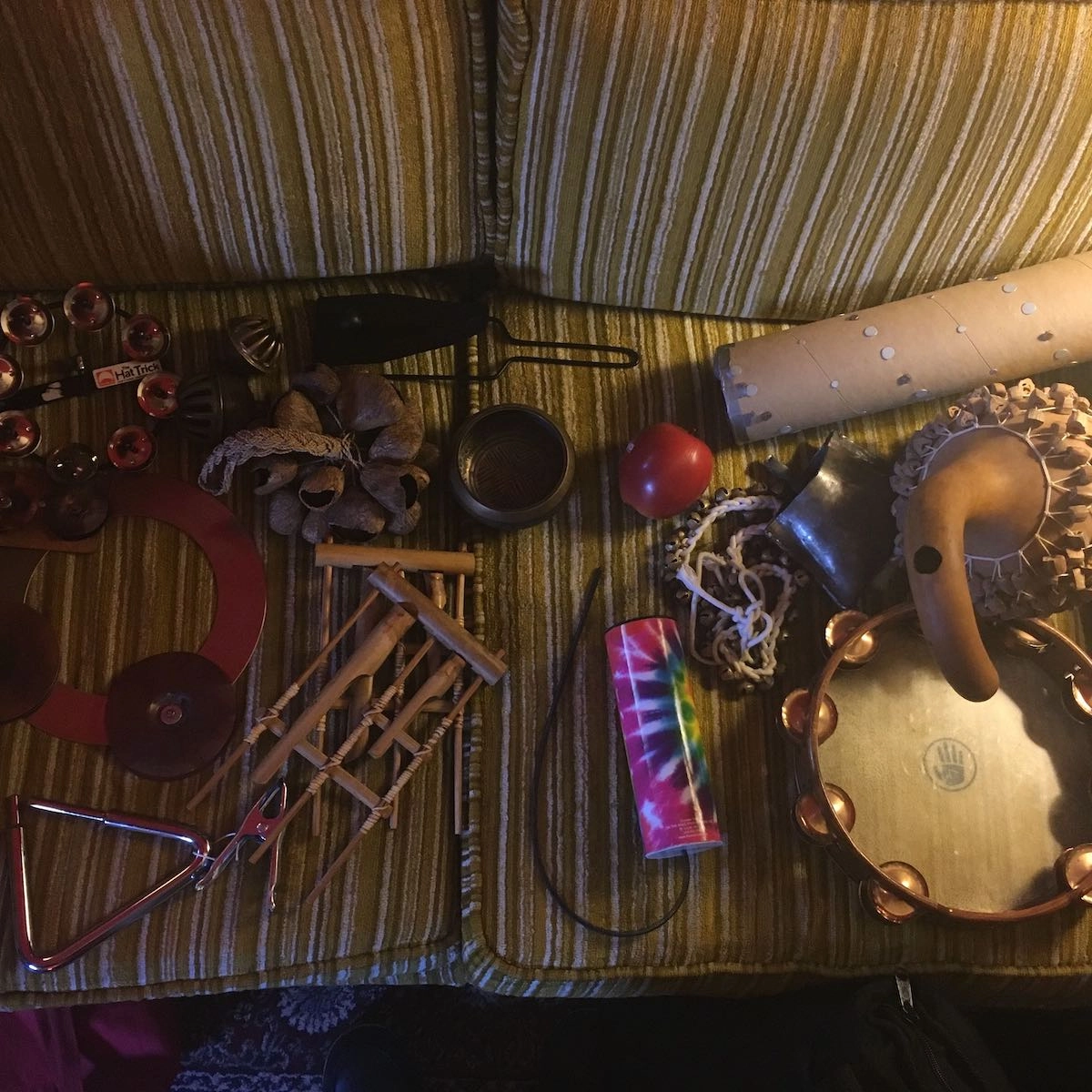 a pile of percussion instruments on a couch in the studio